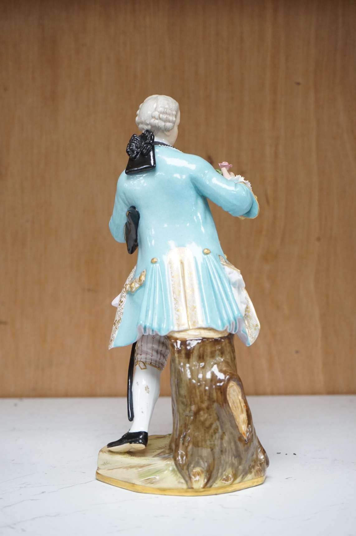 A Meissen figure of a gentleman holding a rose, 19th century, incised model number A58, 19cm high